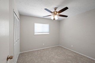 unfurnished bedroom featuring light colored carpet, a closet, and ceiling fan