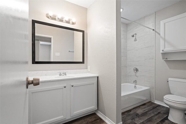 full bathroom with toilet, tiled shower / bath combo, hardwood / wood-style flooring, and vanity