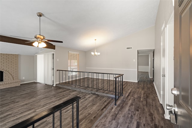 interior space with lofted ceiling, dark wood-type flooring, and an inviting chandelier