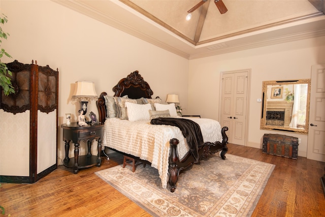 bedroom featuring hardwood / wood-style flooring, ceiling fan, ornamental molding, and high vaulted ceiling