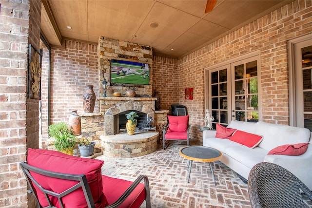 view of patio / terrace featuring an outdoor living space with a fireplace and french doors