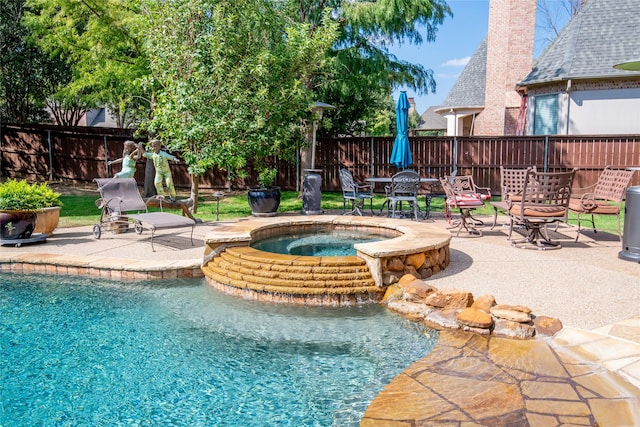 view of pool with a patio area and an in ground hot tub