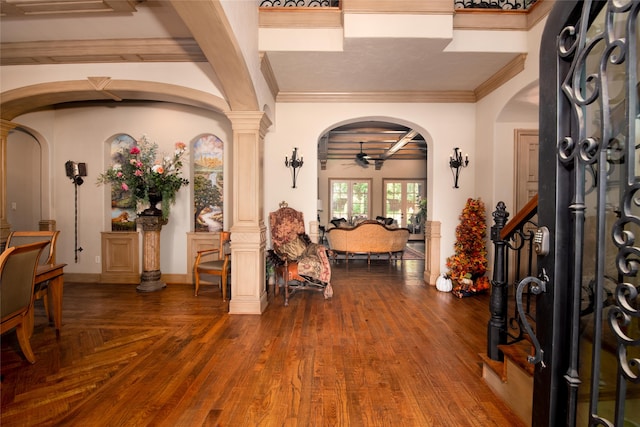 entryway featuring hardwood / wood-style flooring, ornate columns, ceiling fan, and ornamental molding