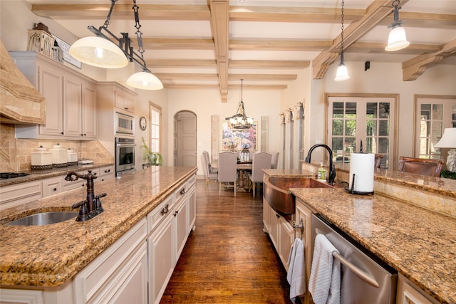 kitchen with backsplash, decorative light fixtures, sink, and stainless steel appliances