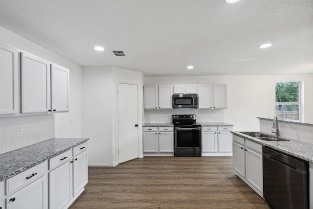 kitchen featuring light stone counters, dark wood-type flooring, sink, white cabinets, and appliances with stainless steel finishes