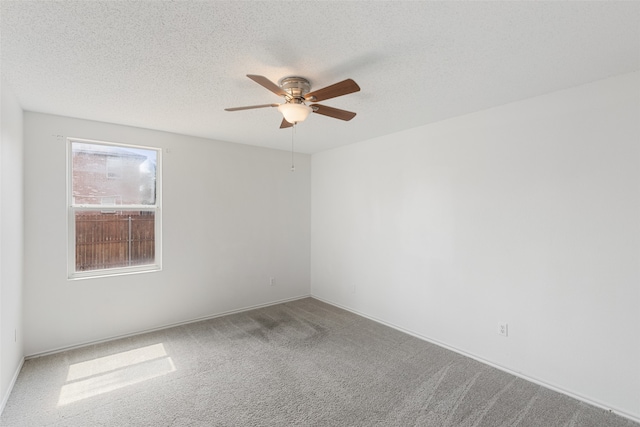 carpeted empty room featuring ceiling fan and a textured ceiling