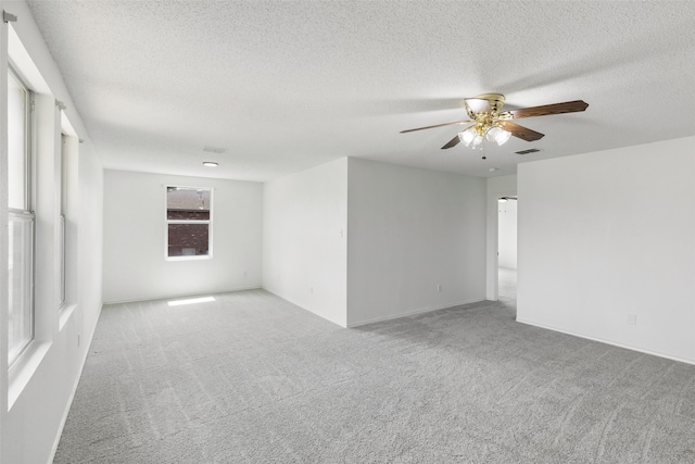 carpeted spare room with ceiling fan and a textured ceiling