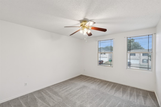 carpeted spare room with ceiling fan and a textured ceiling