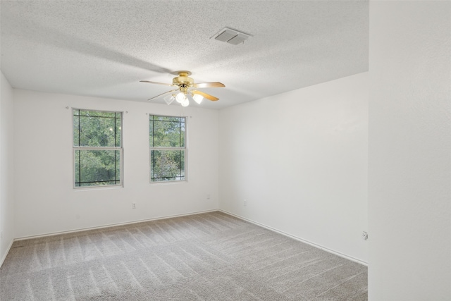 spare room featuring carpet floors, a textured ceiling, and ceiling fan