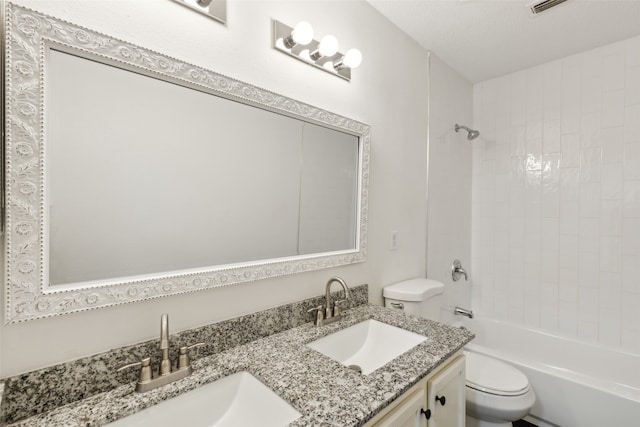 full bathroom featuring vanity, tiled shower / bath combo, toilet, and a textured ceiling