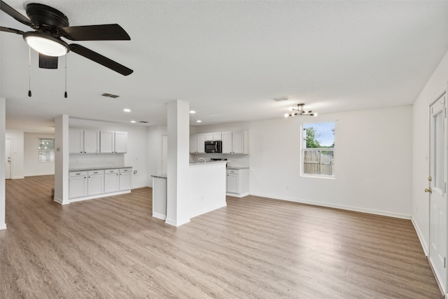 unfurnished living room featuring a textured ceiling, light hardwood / wood-style floors, and ceiling fan