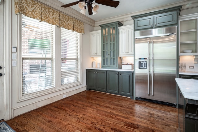 kitchen featuring stainless steel built in fridge, crown molding, dark wood-type flooring, ceiling fan, and decorative backsplash