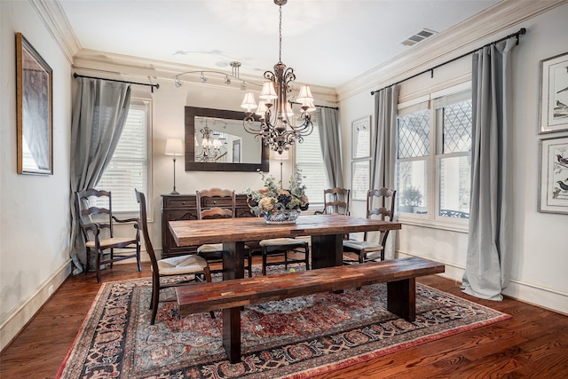 dining space with ornamental molding, dark hardwood / wood-style flooring, a healthy amount of sunlight, and a chandelier