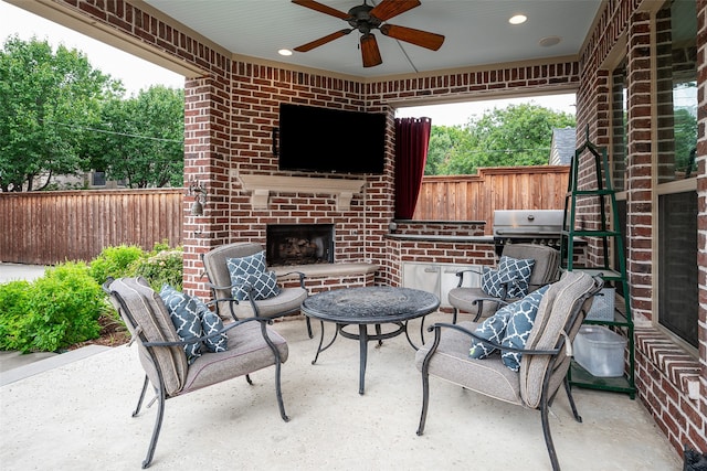 view of patio / terrace featuring an outdoor brick fireplace, exterior kitchen, grilling area, and ceiling fan