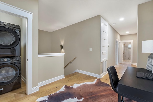 office area with light wood-type flooring, recessed lighting, baseboards, and stacked washer and clothes dryer