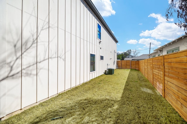 view of home's exterior with central AC, board and batten siding, a fenced backyard, and a lawn