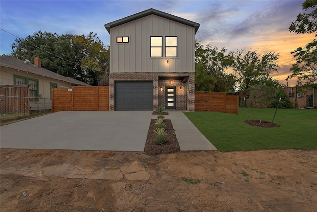 view of front of property with a garage, brick siding, fence, a yard, and board and batten siding