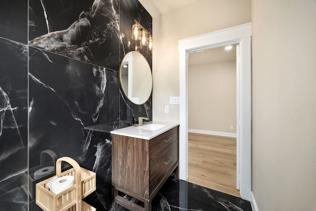 bathroom with baseboards, wood finished floors, and vanity