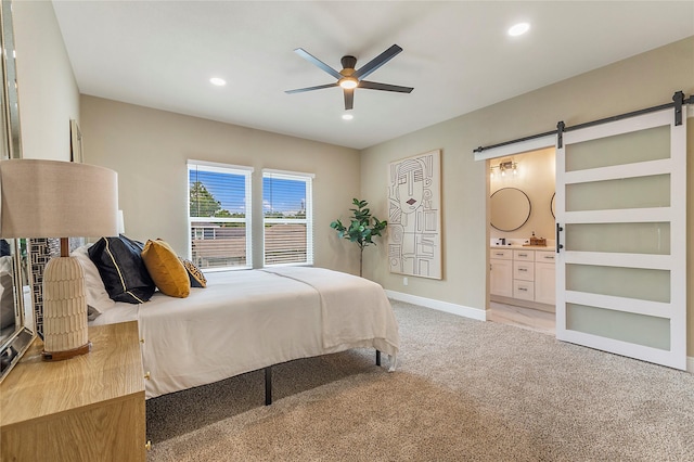 bedroom with light carpet, a barn door, baseboards, and recessed lighting