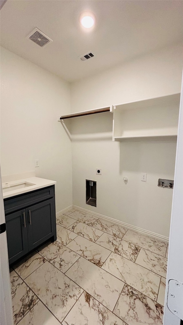 laundry area featuring cabinets, gas dryer hookup, and electric dryer hookup