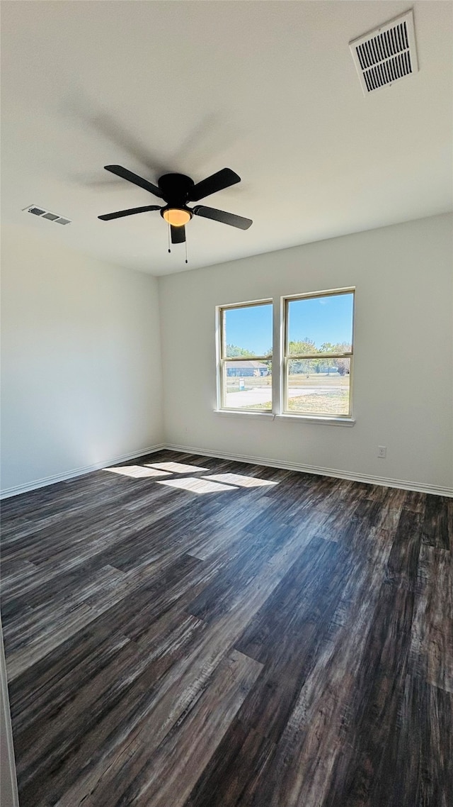 empty room with ceiling fan and dark hardwood / wood-style flooring