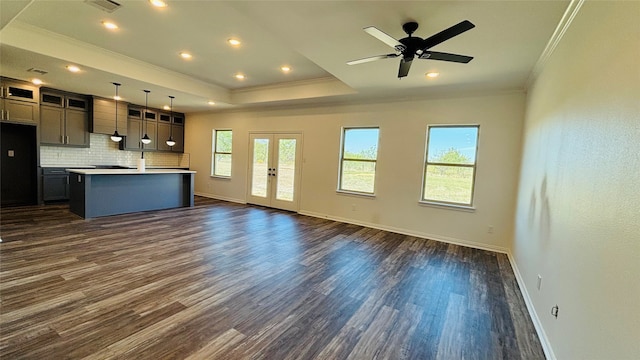 unfurnished living room featuring ornamental molding, plenty of natural light, and dark wood-type flooring