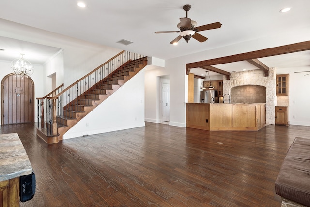 unfurnished living room with ceiling fan with notable chandelier, dark wood-type flooring, and beamed ceiling