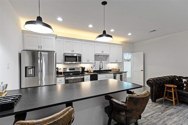 6770 Fm 1372nd Rd, North Zulch, TX 77872 - kitchen featuring appliances with stainless steel finishes, dark countertops, a sink, visible vents, and a kitchen breakfast bar