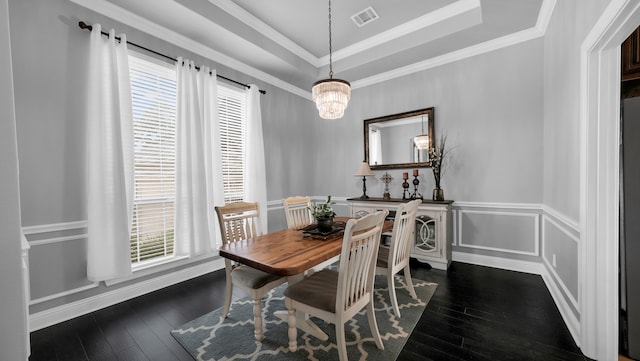 dining area featuring plenty of natural light, dark wood-type flooring, and a tray ceiling