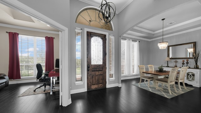 entryway featuring ornamental molding, dark hardwood / wood-style floors, a healthy amount of sunlight, and a notable chandelier