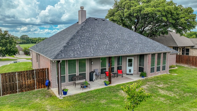 back of house featuring a patio area and a lawn