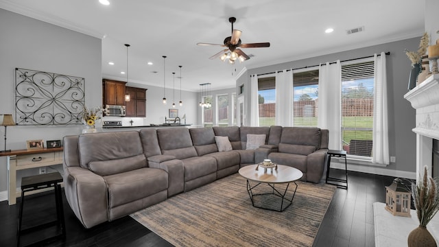 living room with ornamental molding, ceiling fan, and dark wood-type flooring