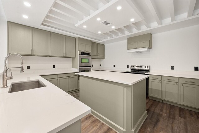 kitchen featuring green cabinets, a center island, stainless steel appliances, dark hardwood / wood-style flooring, and sink