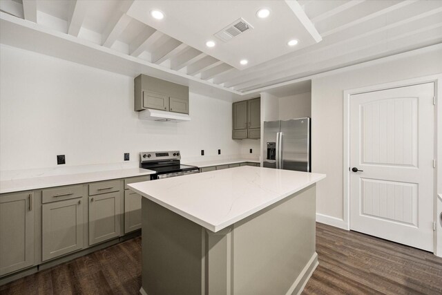 kitchen featuring appliances with stainless steel finishes, light stone countertops, dark hardwood / wood-style floors, a kitchen island, and beam ceiling