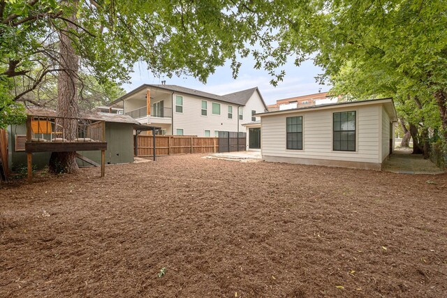 back of house featuring a wooden deck and a patio area