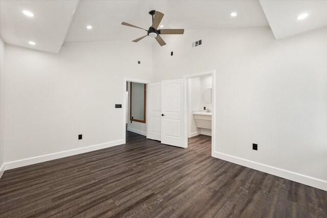 spare room featuring dark wood-type flooring, ceiling fan, and high vaulted ceiling