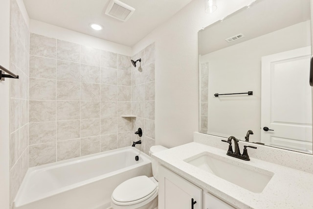 full bathroom with tiled shower / bath, vanity, and toilet