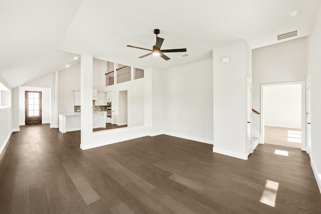 unfurnished living room featuring ceiling fan, dark hardwood / wood-style flooring, and a high ceiling