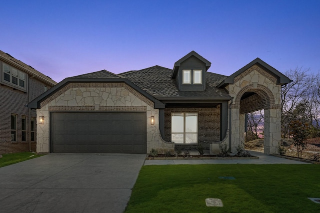 view of front facade with a yard and a garage