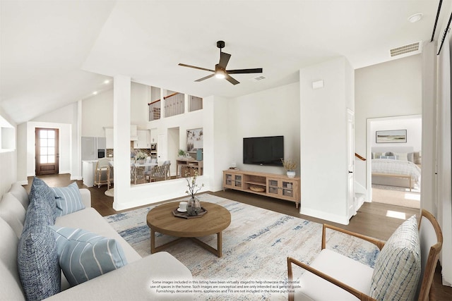 living room with dark hardwood / wood-style flooring, ceiling fan, and vaulted ceiling