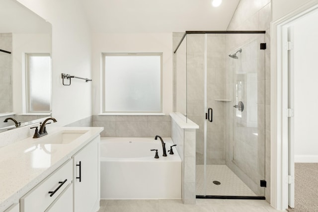 bathroom with vaulted ceiling, tile patterned flooring, a healthy amount of sunlight, vanity, and plus walk in shower