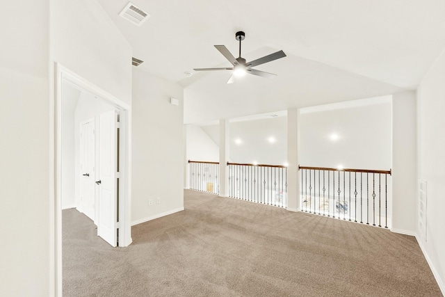 carpeted spare room with ceiling fan and vaulted ceiling