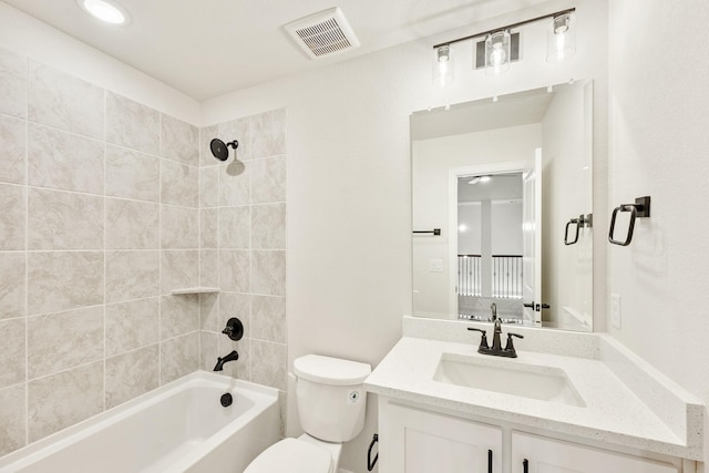 full bathroom with toilet, tiled shower / bath, and vanity