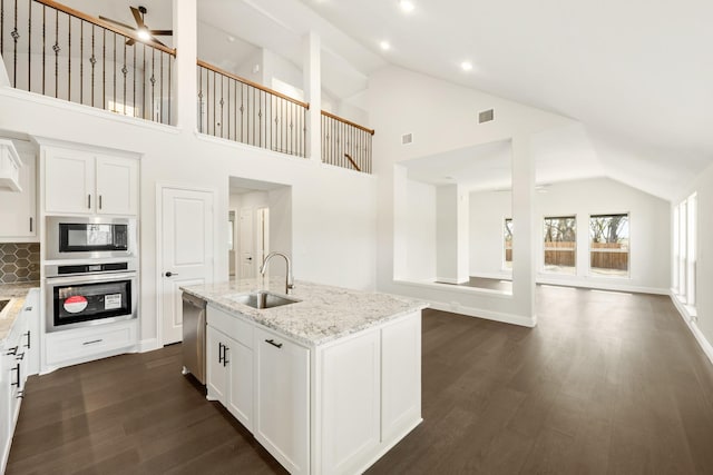 kitchen with dishwasher, high vaulted ceiling, a kitchen island with sink, backsplash, and sink