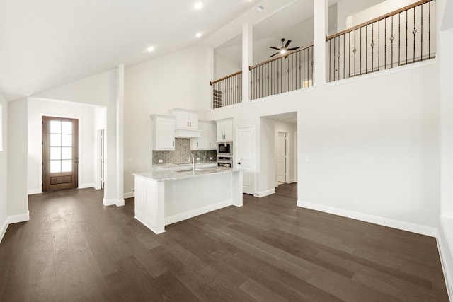 kitchen with dishwasher, a center island with sink, light hardwood / wood-style floors, high vaulted ceiling, and sink