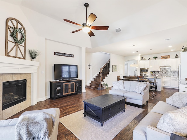 living room featuring ceiling fan, a fireplace, and dark hardwood / wood-style flooring