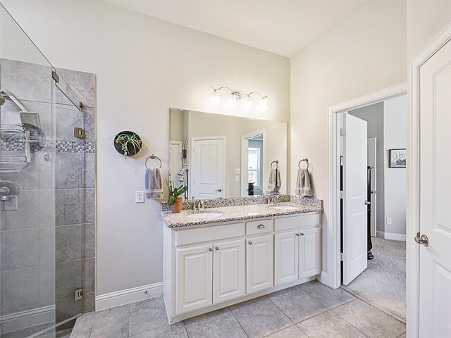 bathroom with walk in shower, vanity, and tile patterned flooring