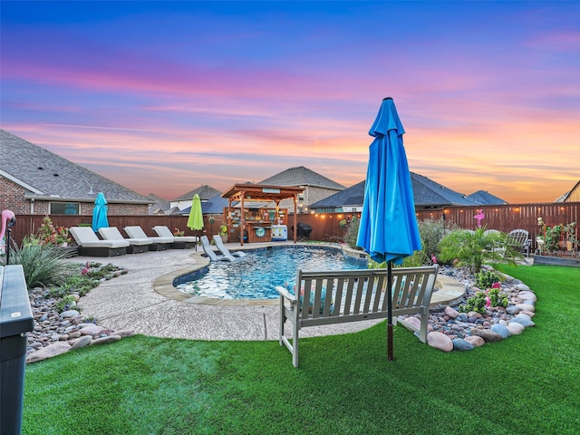 pool at dusk with a yard and a patio