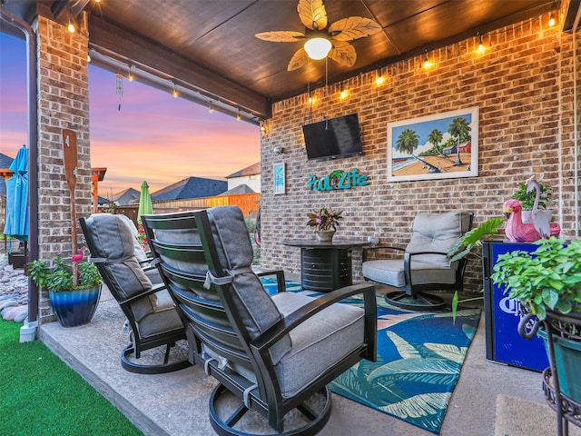 patio terrace at dusk featuring ceiling fan