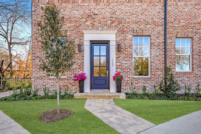 property entrance with a lawn